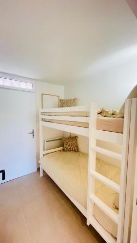 une chambre avec deux lits superposés dans une pièce dans l'établissement Bain De Soleil refait à neuf, bord de plage et piscine, proche de Saint Tropez, à Gassin