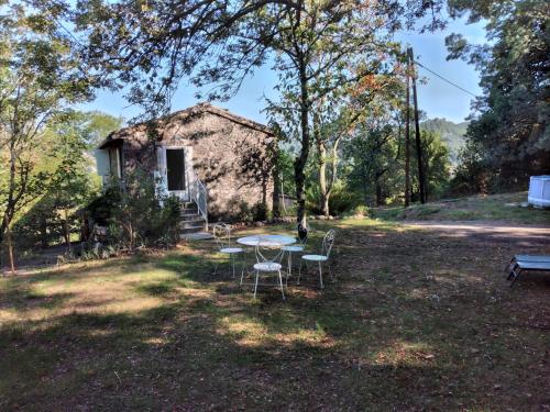 une table et des chaises devant une maison dans l'établissement Le Cocon de la Corgne, à Anduze