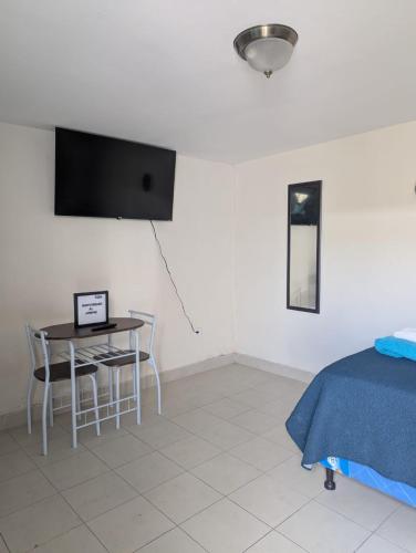 a bedroom with a table and chairs and a tv at 2 minutos de Mall Las Cascadas Apartamento Completo in Tegucigalpa
