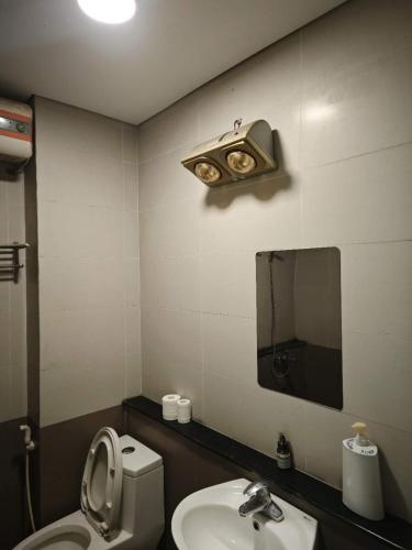 a bathroom with a toilet and a sink and a mirror at WRX guest house in Hanoi