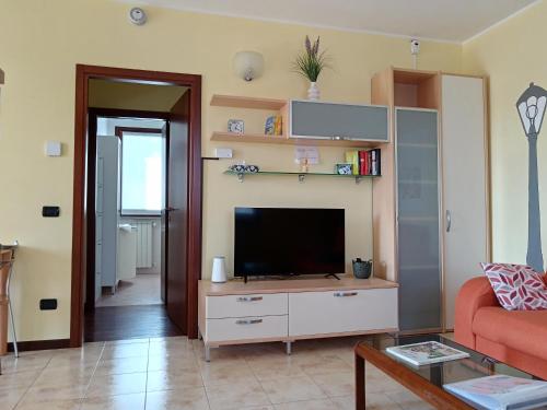 a living room with a television on a cabinet at Appartamento dei Salici in Gallarate