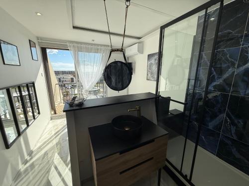 une salle de bain avec un lavabo et une douche en verre dans l'établissement Studio Naturiste WILD Heliopolis F 96, au Cap d'Agde