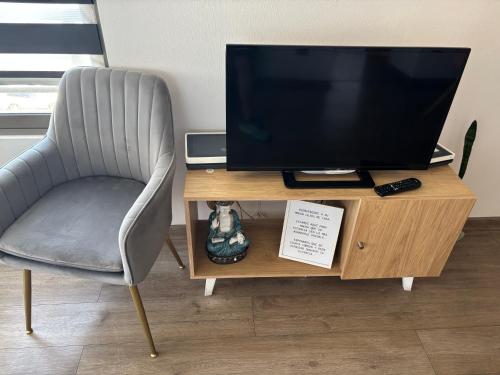 a chair sitting next to a desk with a television at Hermoso departamento in Iquique