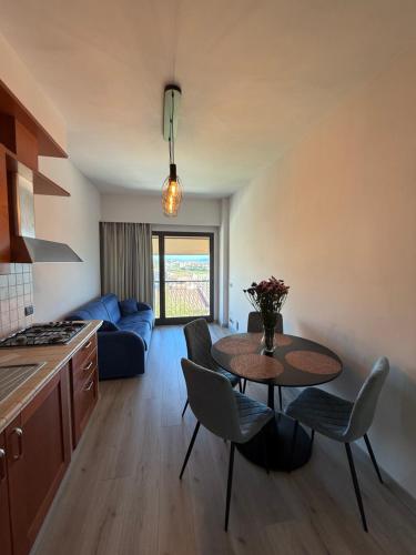 a kitchen and living room with a table and chairs at ApartHotel Del Corso in Castiglione della Pescaia