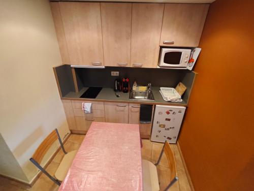 a small kitchen with a table and a microwave at Studio idéal court séjour in Porté-Puymorens