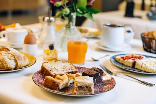 a table with plates of breakfast foods on it at Hotel CampingPark Steiner in Laives
