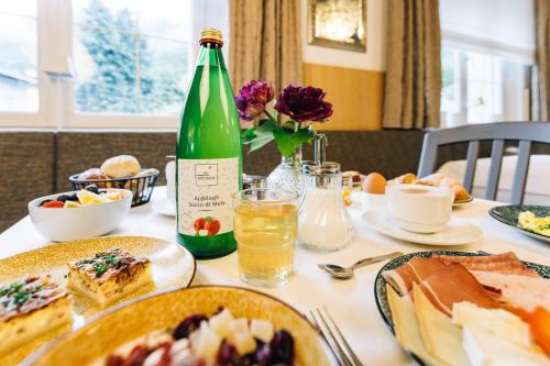 a table with plates of food and a bottle of wine at Hotel CampingPark Steiner in Laives