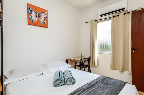 una camera da letto con un letto e un paio di pantofole sopra di A2-CantoForte - 200 metrosPraia - ARCond - Garagem - Wifi - Ideal para Família a Praia Grande
