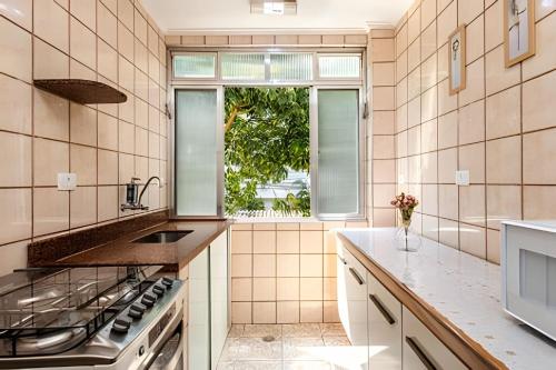 una cucina con fornelli, lavello e finestra di A2-CantoForte - 200 metrosPraia - ARCond - Garagem - Wifi - Ideal para Família a Praia Grande