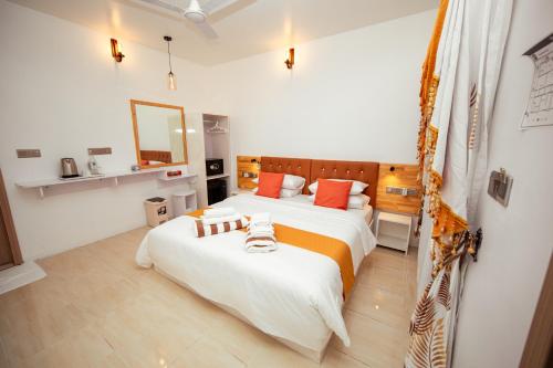 Un dormitorio con dos camas con sábanas naranjas y blancas. en Velana Vibes at Mathiveri, en Mathiveri