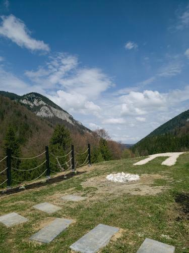 a field with a fence and mountains in the background at A Way To Nature in Măgura