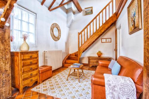 a living room with a staircase and a couch at La Maison Fabane - Hypercentre de Carentan in Carentan