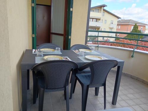 a table with chairs and plates on a balcony at Appartamento dei Salici in Gallarate