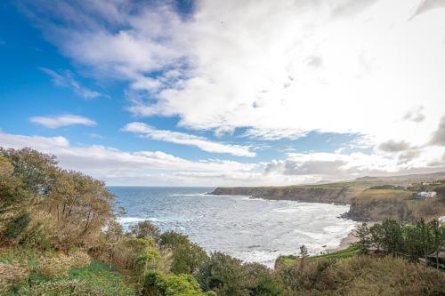 a view of a beach with the ocean and clouds at Eagle's Perch in Porto Formoso in Porto Formoso