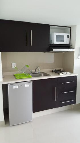 a kitchen with a sink and a microwave at Grupo Kings Suites - Bosque de Duraznos 72 in Mexico City