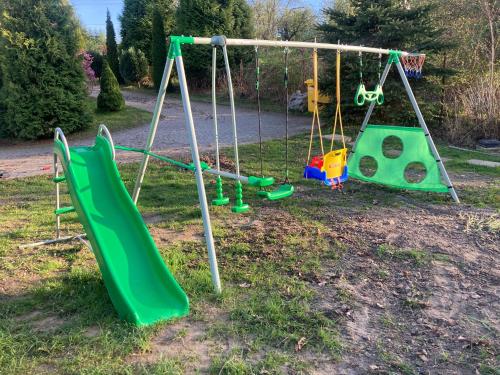 a playground with two swings and a slide at Tymi3 Dom na wzgórzu przy stoku in Przemyśl