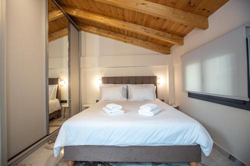 a bedroom with a bed with two towels on it at City View Loft in Ioannina