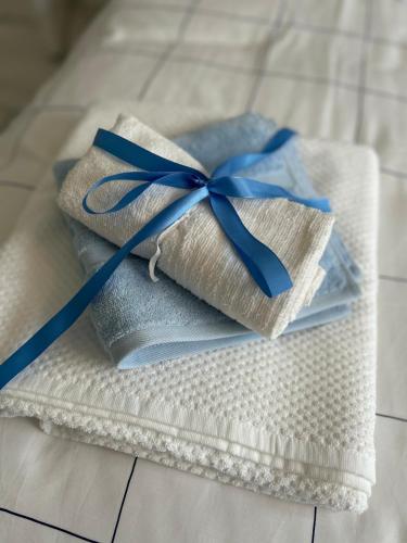 two wrapped towels with a blue ribbon on a bed at Bella Beach House in Whitley Bay
