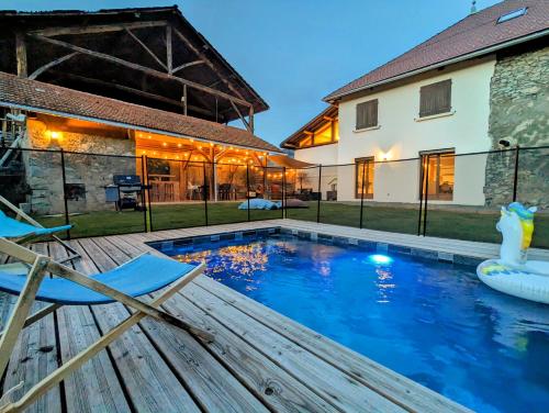 une maison avec une piscine et deux chaises dans l'établissement La Villa Fontaine & Piscine chauffée - Corps d Uriage, à Saint-Martin-d'Uriage