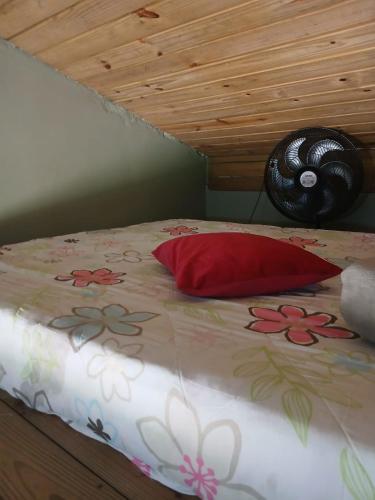 a bed with a bedspread with flowers on it at Tatiane cristino in Imbituba