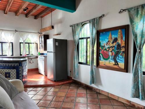 a living room with a painting on the wall at Casa Pajaros Balcony in Cruz de Huanacaxtle