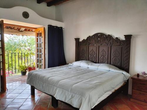 a bedroom with a large bed with a wooden headboard at Casa Pajaros Balcony in Cruz de Huanacaxtle