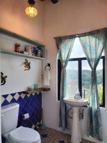 a bathroom with a toilet and a sink and a window at Casa Pajaros Balcony in Cruz de Huanacaxtle