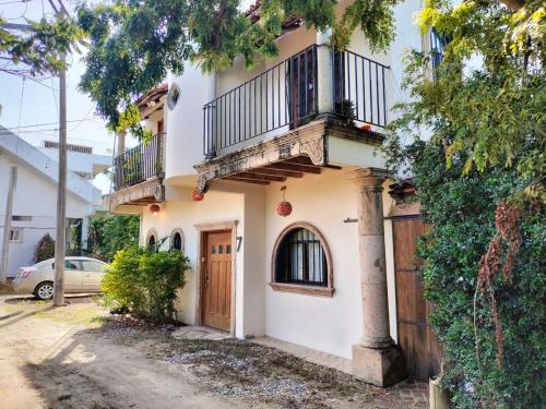 a white house with a balcony and a garage at Casa Pajaros Balcony in Cruz de Huanacaxtle