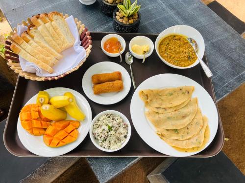 a tray with plates of food on a table at Wild Blossom Sigiriya in Sigiriya