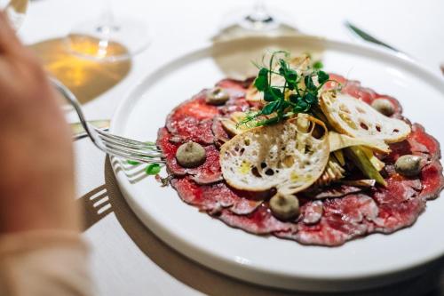 a plate of food on a table with a fork at Hotel CampingPark Steiner in Laives