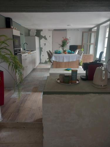 un salon avec une table et une cuisine dans l'établissement La cachette Provençale, aux Angles (Gard)