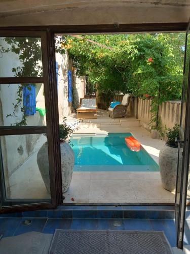 une piscine vue par une fenêtre dans l'établissement La cachette Provençale, aux Angles (Gard)