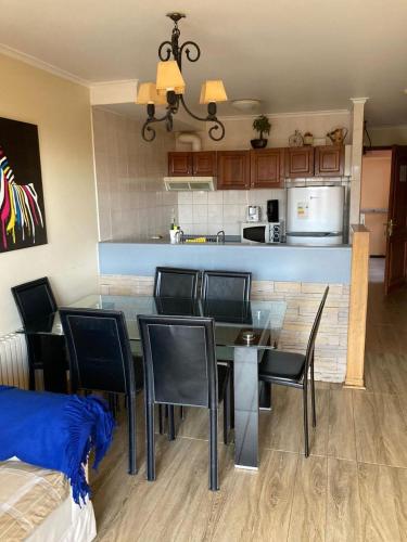 a dining room with a table and chairs and a kitchen at DEPARTAMENTOS TERMAS DE CHILLAN in Nevados de Chillan
