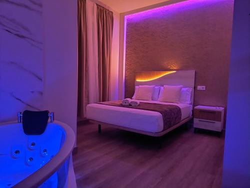 una camera con letto e illuminazione viola di Paradise Suites Madrid a Madrid