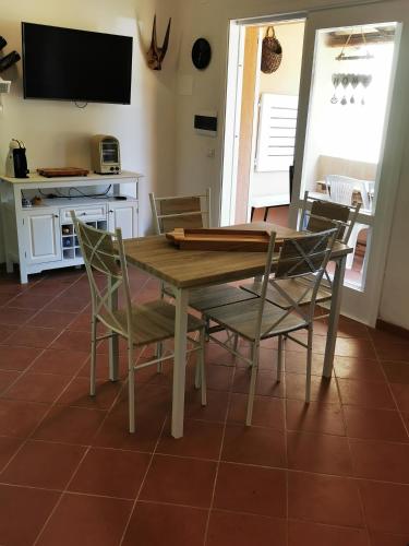 a dining room with a wooden table and chairs at Live Sea and Nature in Costa Paradiso