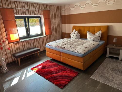 a bedroom with a bed and a red rug at Ferienhaus Lübke Souterrain in Mühlhausen