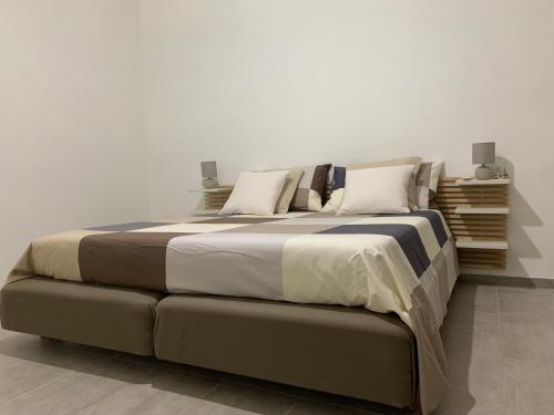 a large bed in a white room with at NEW piscina coppa di fuoco in Fasano