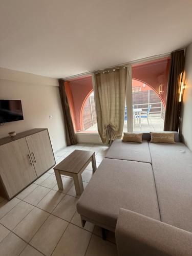 Cette chambre comprend 3 lits, un canapé et une fenêtre. dans l'établissement T2 Cap Agde Terrace Piscine, au Cap d'Agde