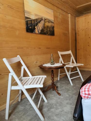 two chairs and a table in a room at Burgbühler Guesthouse in Lenk