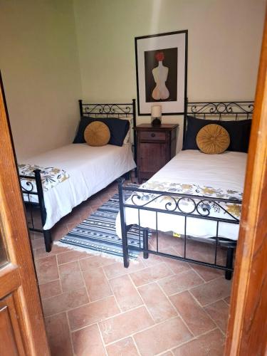 two beds sitting in a room with at Casal'terra - Il Fosso in Salaiola