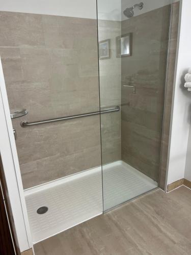 a shower with a glass door in a bathroom at Comfort Inn in Manistique