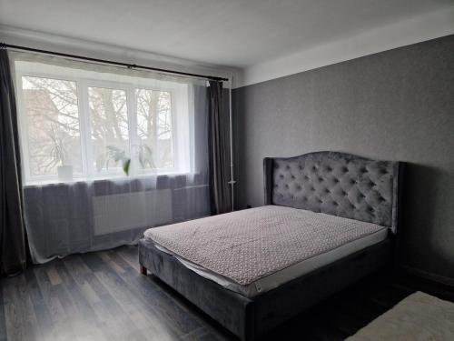 a bedroom with a bed in front of a window at Cozy apartment in Ventspils