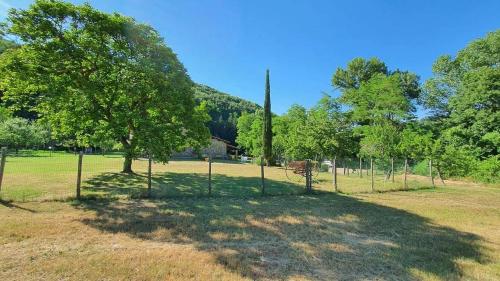 a fence in a field with a tree at Casal'terra - Il Fosso in Salaiola