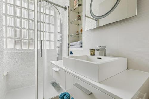une salle de bain blanche avec un lavabo et une douche dans l'établissement Apartment Balcony Paris 16 Auteuil, Parc Des Princes, à Paris
