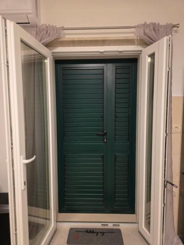 a green door in a room with a window at Dream - sea view apartment in Pučišća