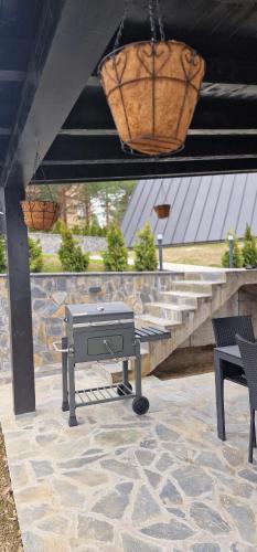 a grill on a patio with a bench and a light at One & Only - Peace For You, Zlatibor in Zlatibor