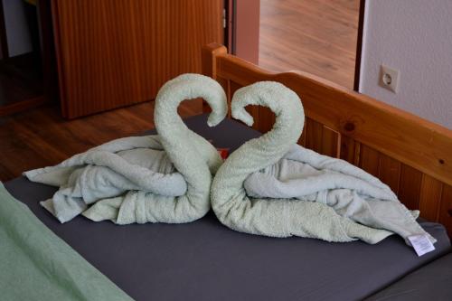 two towel swans sitting on top of a bed at Ferienwohnung Seeblick mit Balkon - Mein Schwarzwaldhäusle in Todtmoos