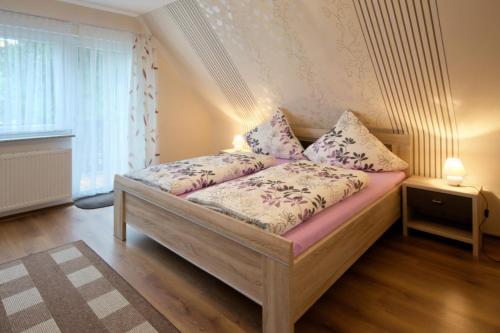 a bedroom with a wooden bed with pillows on it at Ferienwohnung Köpfleblick im Haus Bergblick in Münstertal