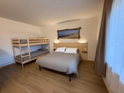 a bedroom with a bed and a bunk bed at La Ca d'Marietta in Paesana