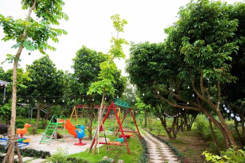 a park with a playground with swings and trees at Toki Homestay - Cawn in Sóc Sơn